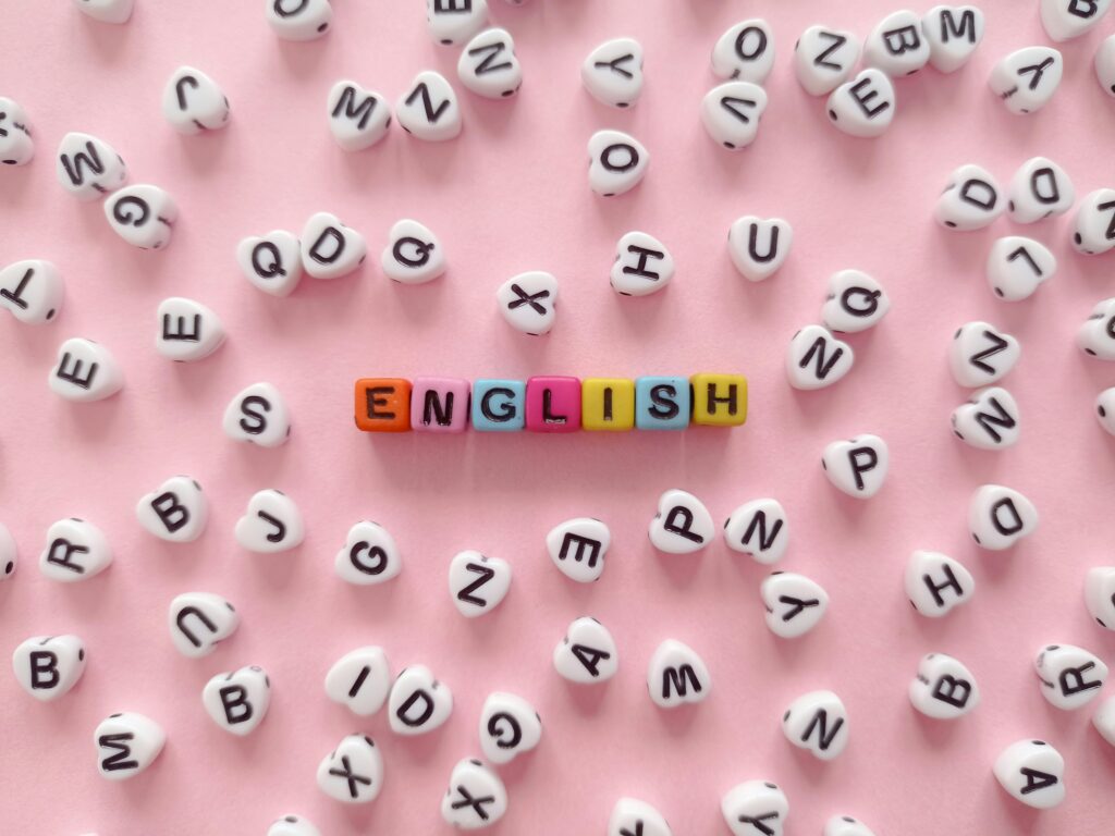pexels photo 10549488 10549488 Scattered letter beads form the word 'English' on a pink background, symbolizing language learning.